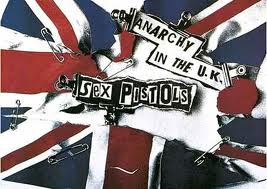 Una imagen del conocido lema de Sex Pistols "Anarchy in the UK", cuyo fondo es la bandera británica un poco desbaratada.
